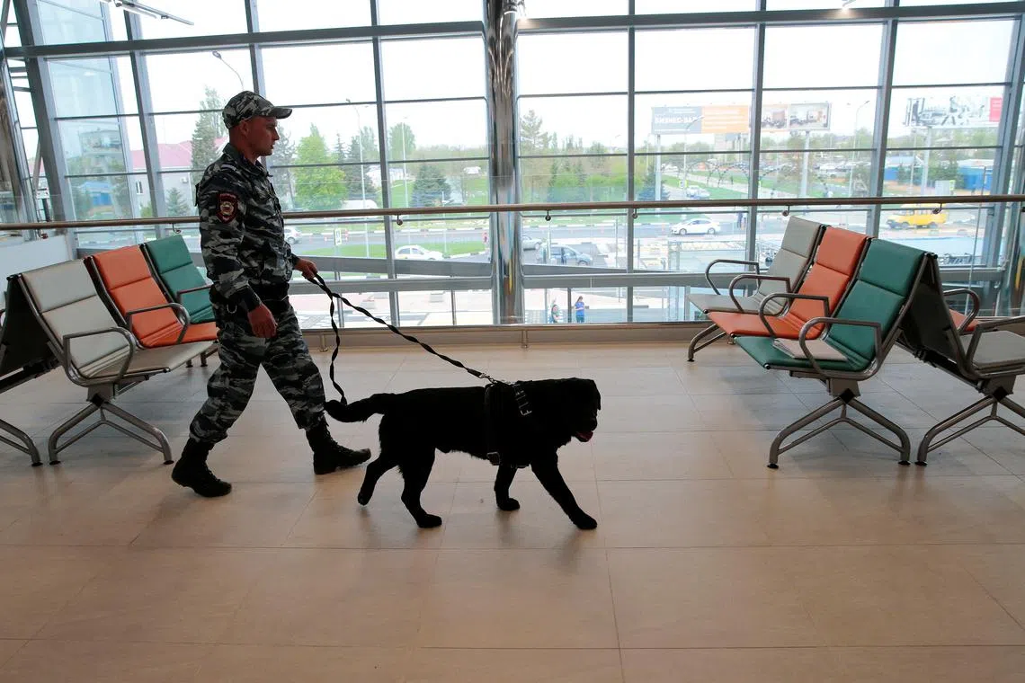 FILE PHOTO: A policeman with a dog walks at the new terminal of Volgograd International Airport, Russia May 8, 2018. REUTERS/Tatyana Makeyeva/File Photo