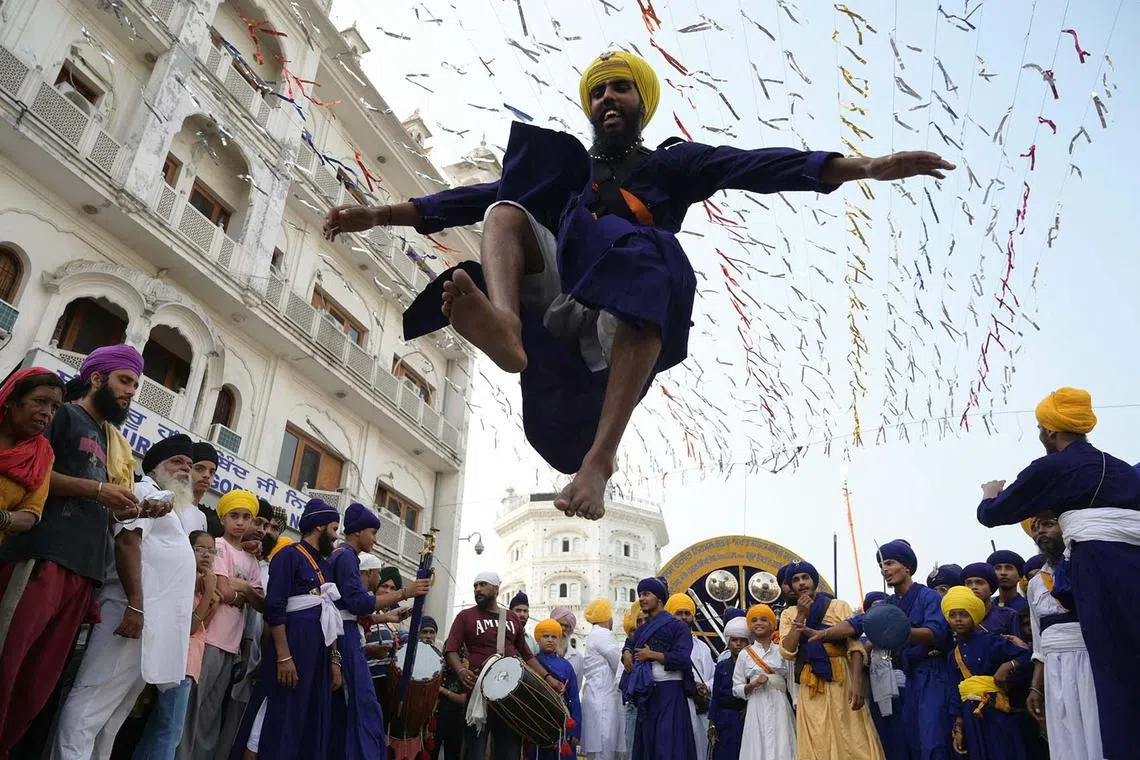 A Sikh man performs the Sikh martial art known as 'Gatka' during a religious procession from Gurudwara Ramsar to Akal Takht Sahib at the Golden Temple in Amritsar, India, on Sept 16, on the occasion of the 419th anniversary of the installation of the 'Guru Granth Sahib' Sikh holy book. 