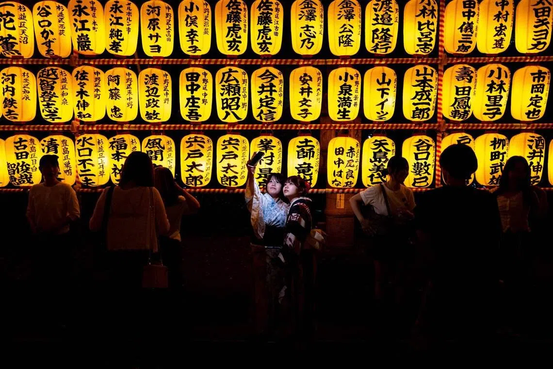 TOPSHOT - People gather in front of thousands of lanterns on display during the Mitama Matsuri, one of the capital's largest summer "obon" festivals, at Yasukuni Shrine in Tokyo on July 15, 2026. (Photo by Philip FONG / AFP)