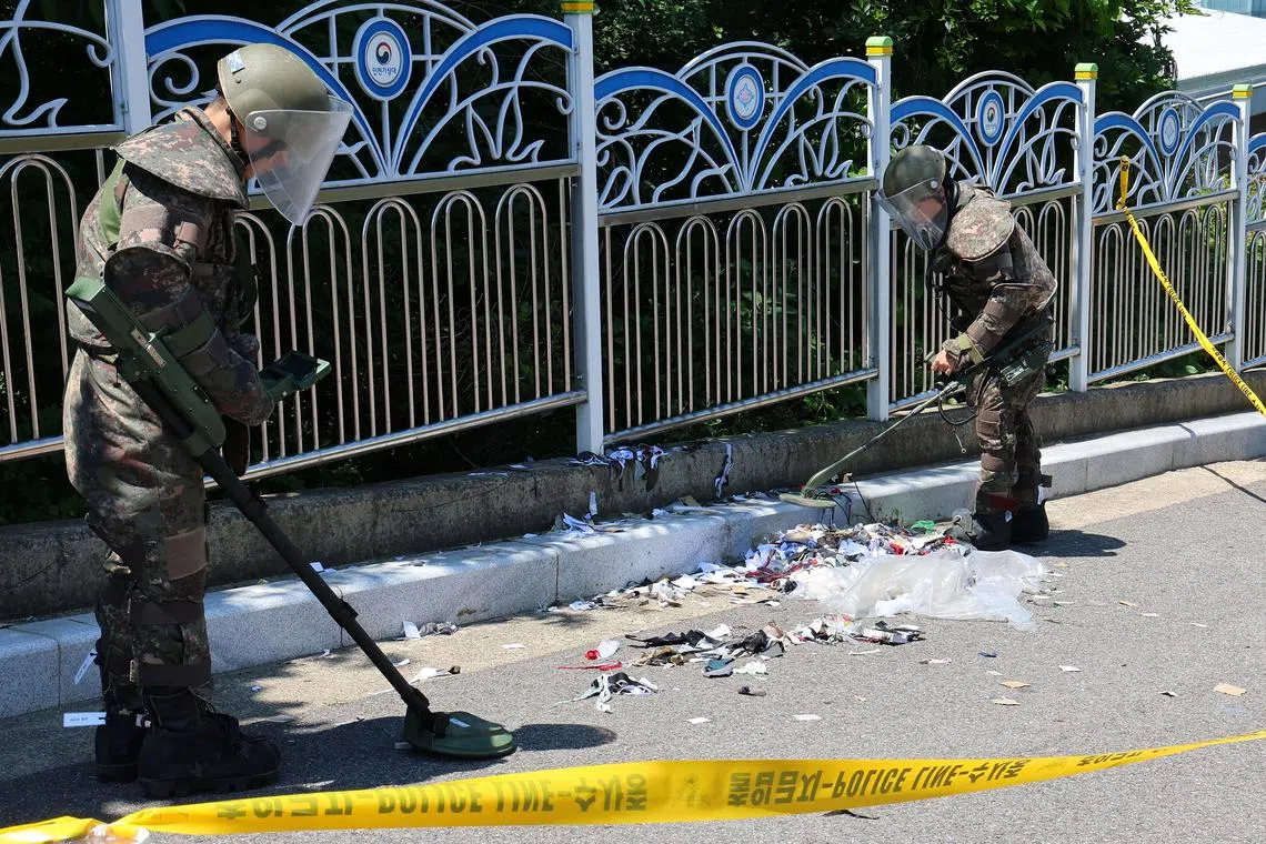 FILE PHOTO: South Korean soldiers examine various objects including what appeared to be trash from a balloon believed to have been sent by North Korea, in Incheon, South Korea, June 2, 2024.     Yonhap via REUTERS/File Photo