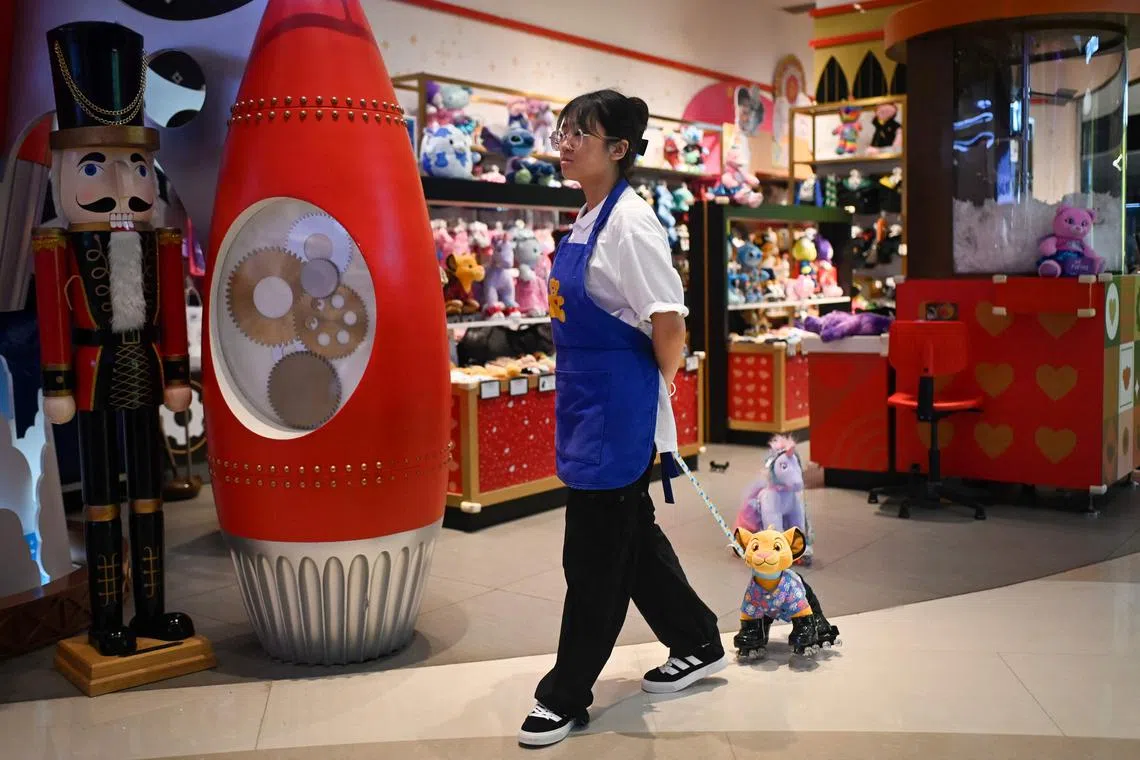 A sales woman waits for customers at a toy store inside a mall at the Central Business District in Beijing.