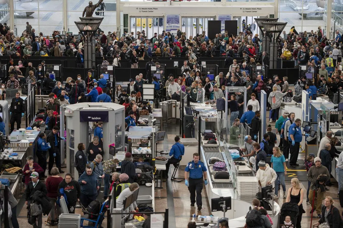 Travellers move through security at Denver airport as flights resume after an early morning FAA system failure.