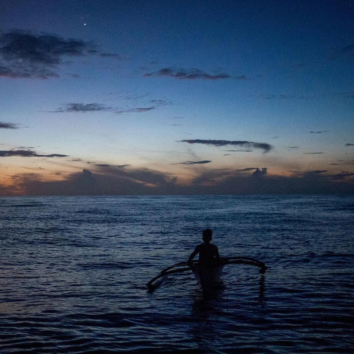 FILE PHOTO: A Filipino fisheman rows a boat during a trip near the disputed Scarborough Shoal, in Masinloc, Zambales province, Philippines, July 18, 2022.  REUTERS/Lisa Marie David/File Photo
