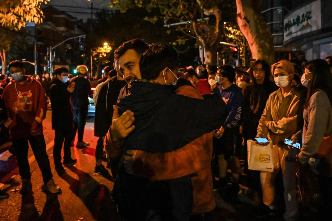 People hug each other in support in Shanghai, China, on Nov 27, 2022, where protests against China's zero-Covid policy took place the night before following a deadly fire in Urumqi, the capital of the Xinjiang region.