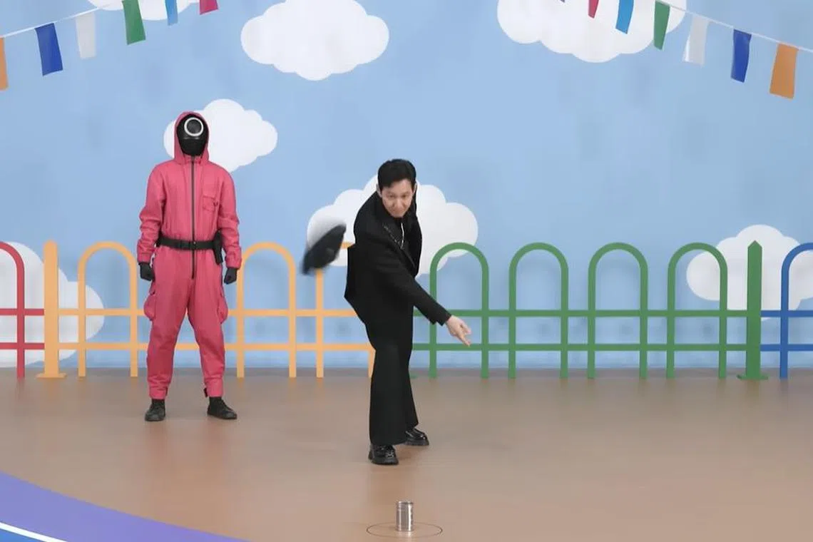 Squid Game 2 actor Lee Jung-jae trying to knock over a can using a slipper in a traditional Filipino game of tumbang preso.