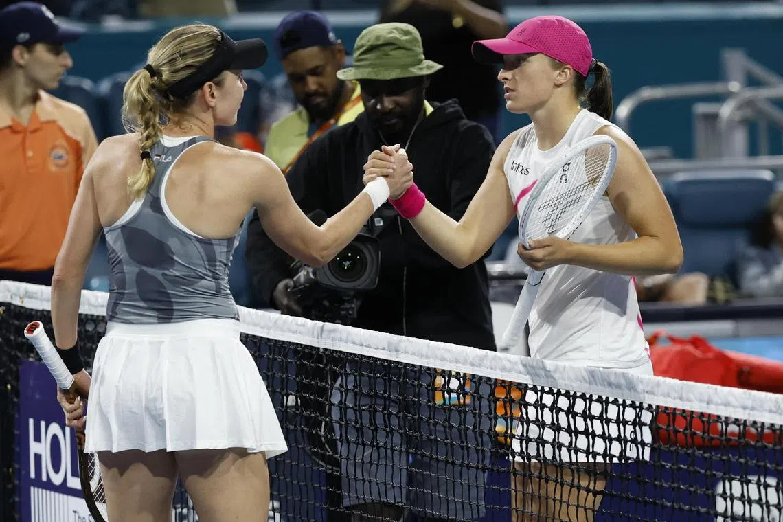 Ekaterina Alexandrova shakes hands with Iga Swiatek after their Miami Open fourth-round match.