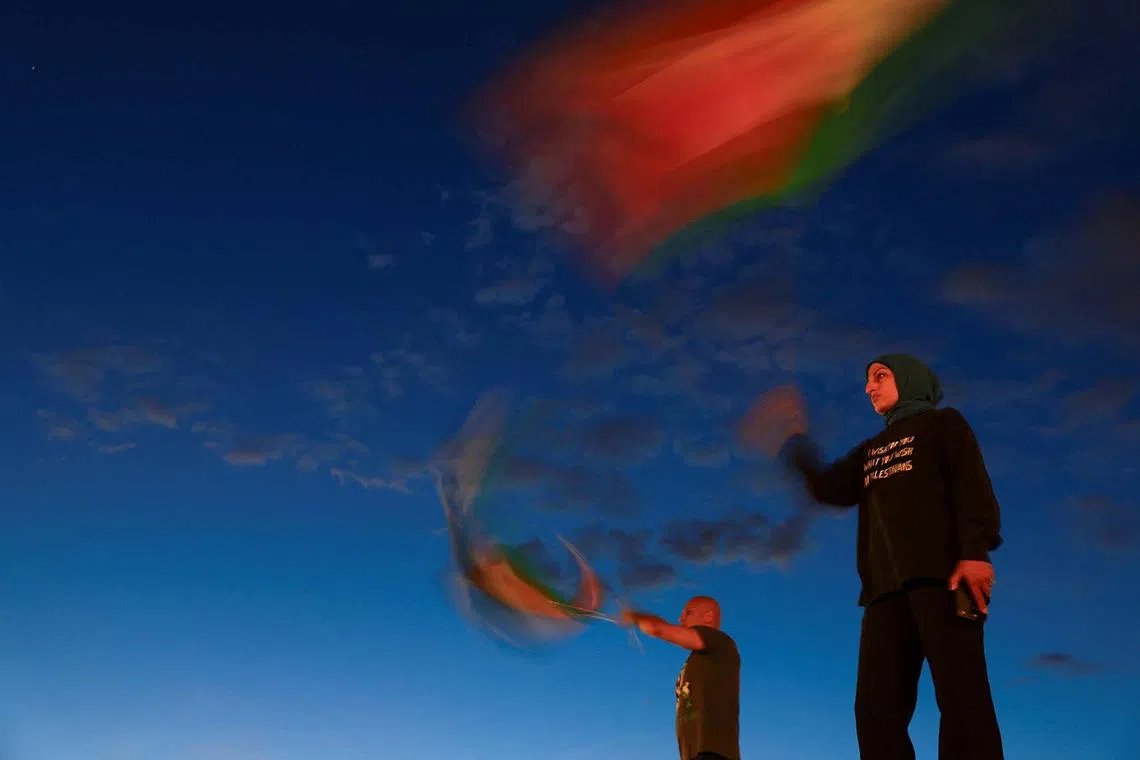 Demonstrators waving Palestinian flags as they take part in a vigil and rally honouring the lives of journalists and medics killed on Monday in Israeli strikes on Nasser hospital in Khan Younis, in the southern Gaza Strip, outside Union Station in Washington, DC, US, Aug 27, 2025. 