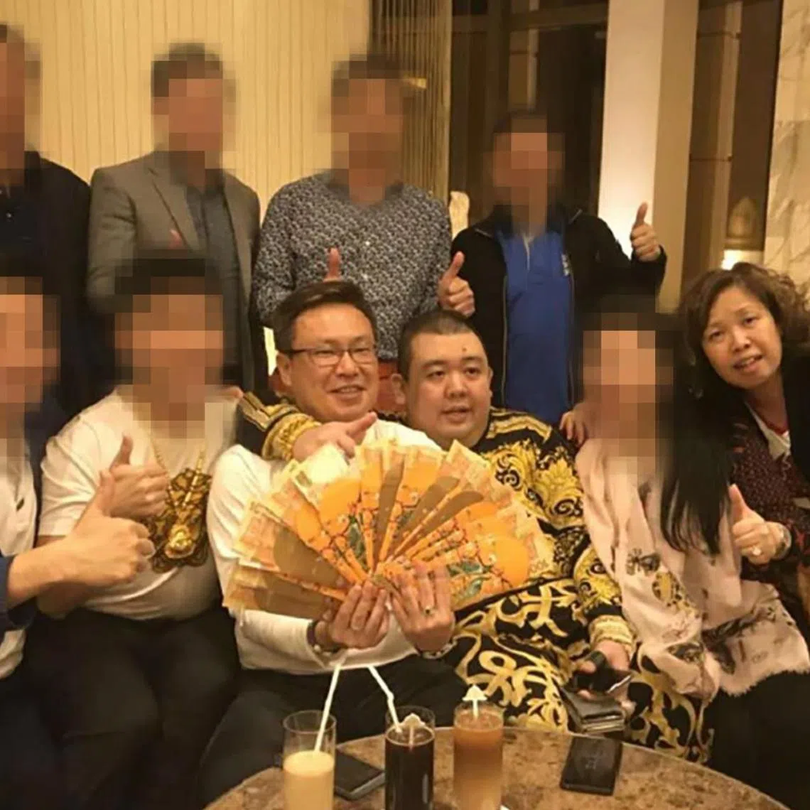Singaporean couple Wan Hoe Keet (seated, left) and his wife Sally Ho with scheme founder Peter Ong in a 2018 meeting in Macau.