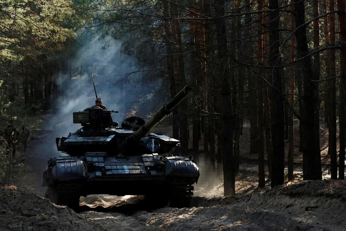 Ukrainian soldiers drive a captured Russian tank after re-fitting it for use in battle.