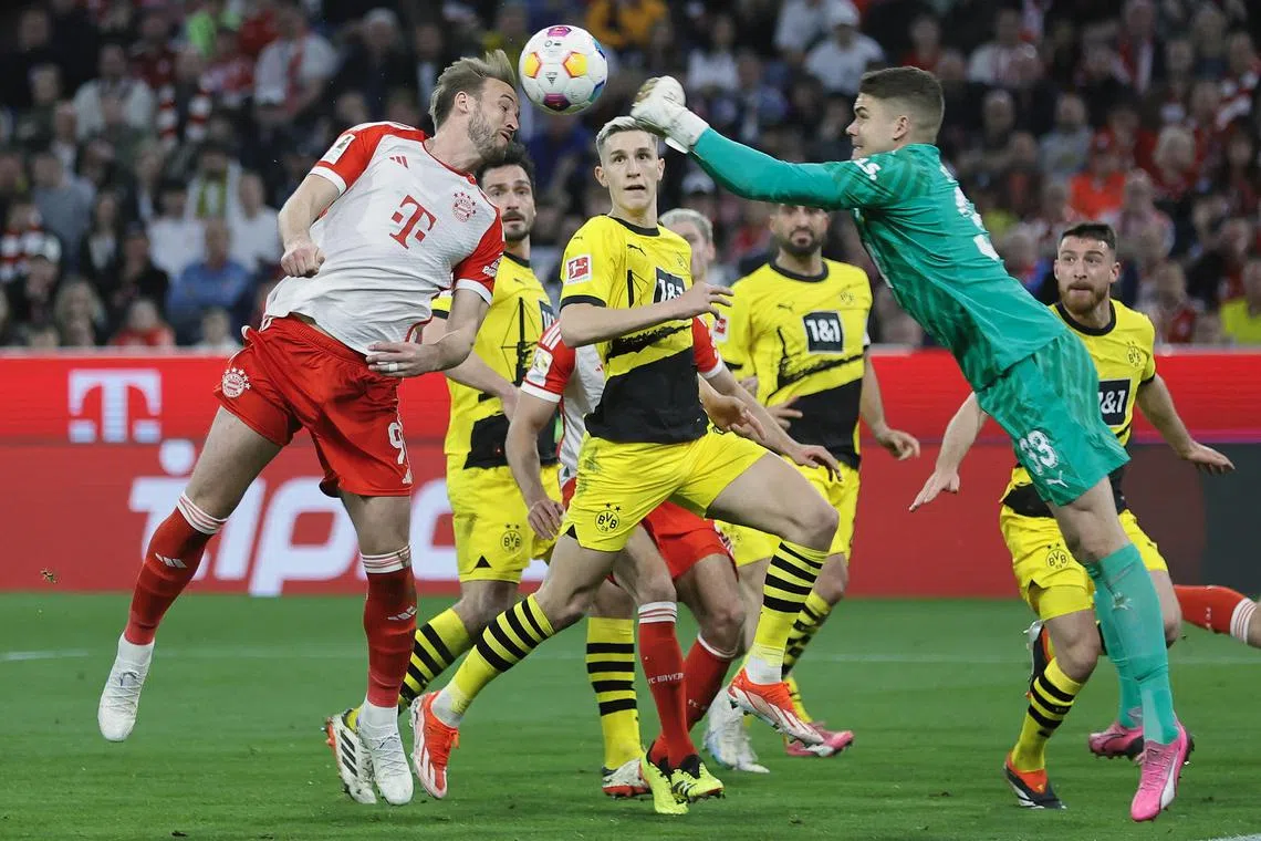 Bayern Munich's Harry Kane sending a header towards goal as Borussia Dortmund's goalkeeper Alexander Meyer attempts to stop him during a league match on March 30. Dortmund won 2-1.