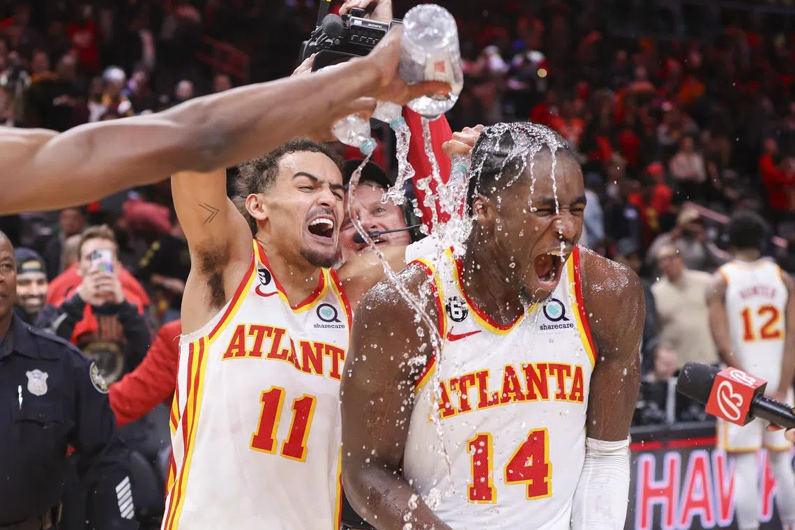 Atlanta Hawks guard Trae Young (No. 11) dumps water on forward A.J. Griffin after an overtime victory against the Toronto Raptors at State Farm Arena on Nov 19.