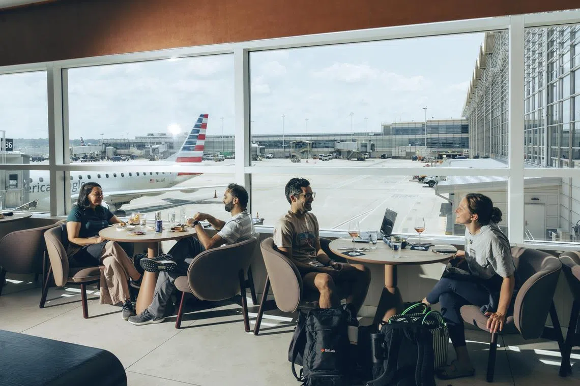 Travelers inside the Capitol One Lounge at John F. Kennedy International Airport in Queens, July 11, 2025. In pursuit of well-heeled fliers, airlines and credit card companies are stocking their elite lounges with caviar, sushi bars and big-name chefs. (Amir Hamja/The New York Times)