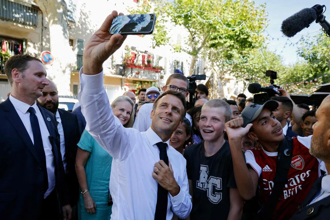 French President Emmanuel Macron poses for a selfie with young residents of Baumes-de-Venise, in southern France.