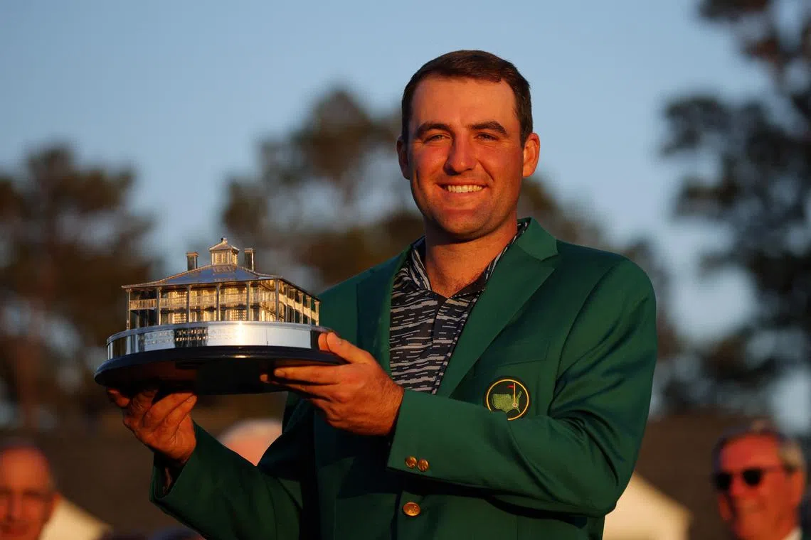 Scottie Scheffler posing in his green jacket with the trophy after winning The Masters in 2022.