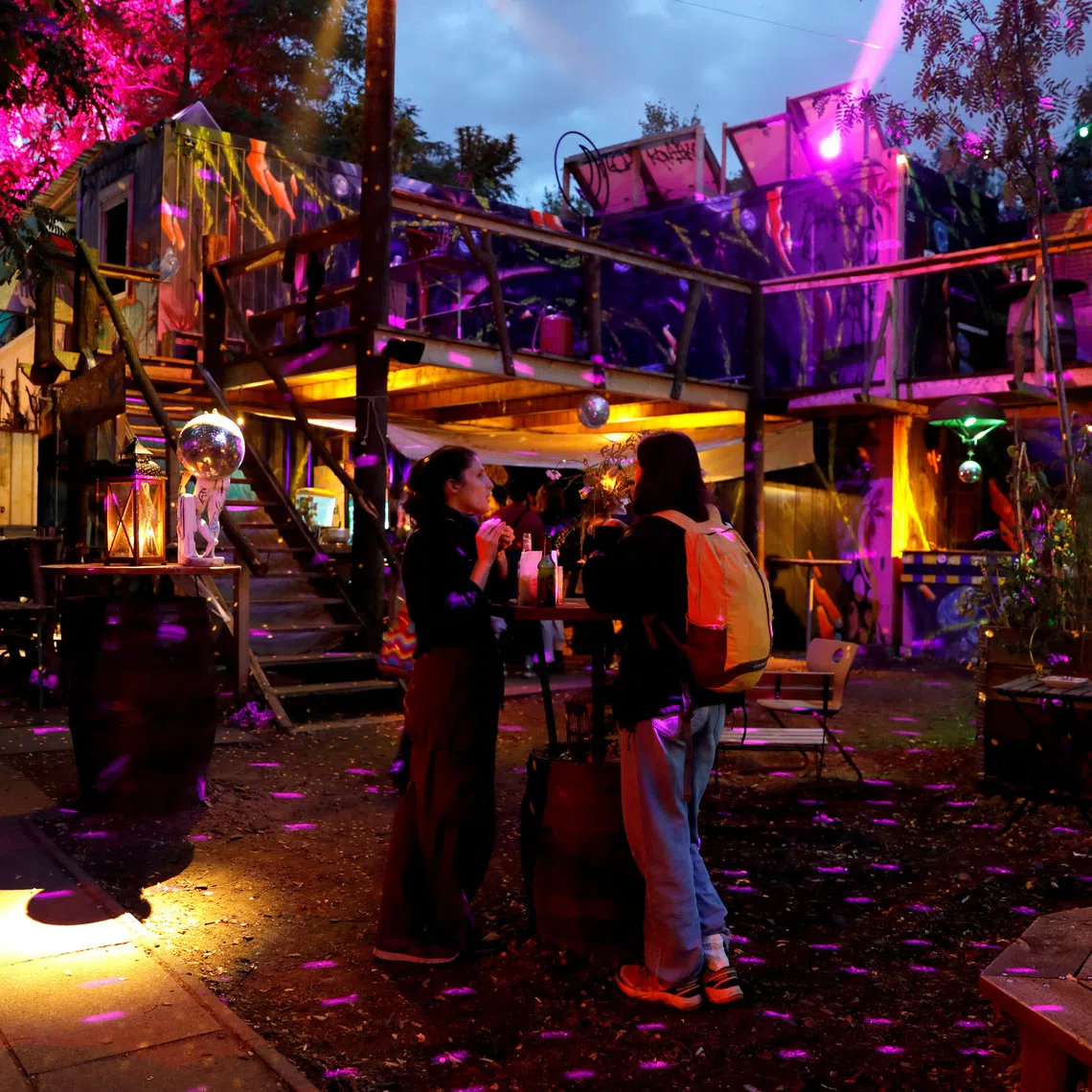 A view of the garden of Zirkus Mond in front of the circus tent, under lights, in Berlin, Germany, September 26, 2026. The area also hosts other structures, including a bar and containers used for artistic purposes. REUTERS/Alessia Cocca
