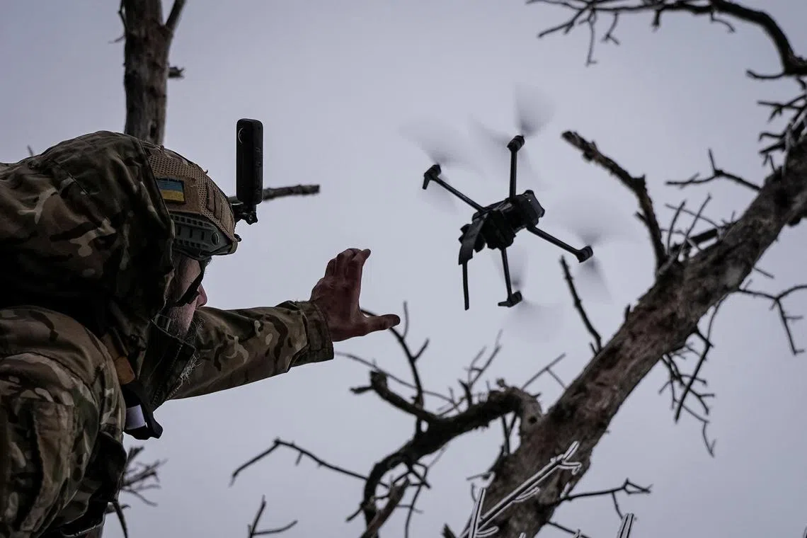 A Ukrainian serviceman launches a kamikaze FPV drone near the city of Bakhmut, amid Russia's invasion of Ukraine.