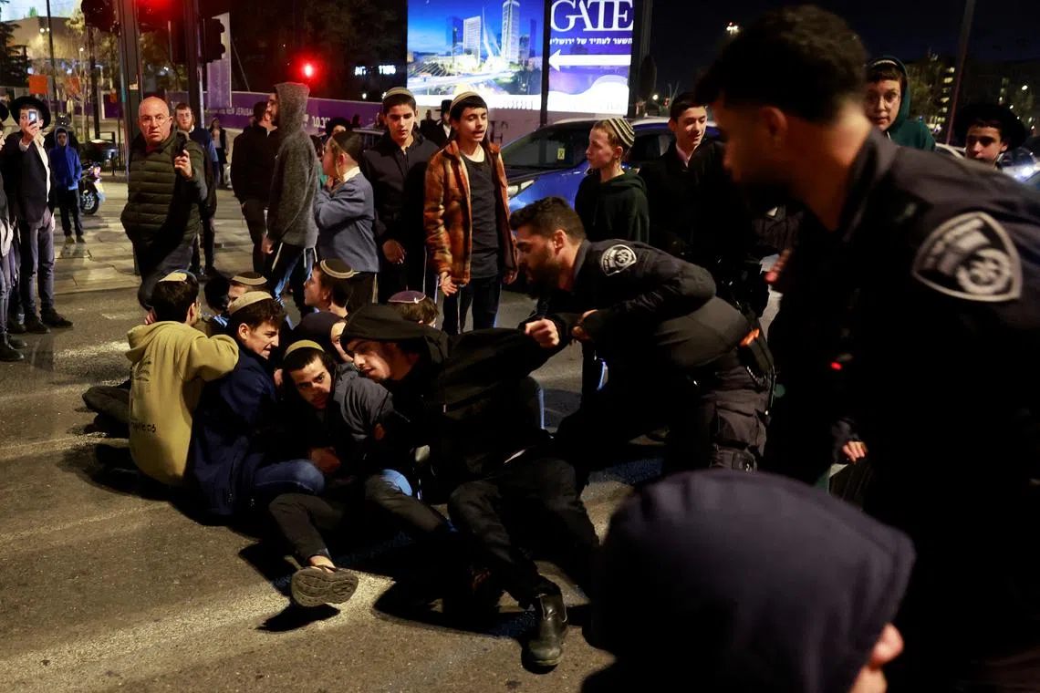 Israeli forces remove people blocking a road to protest a ceasefire deal near the Prime Minister's office in Jerusalem, on Jan 15.