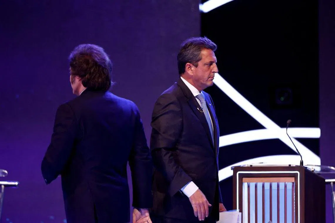 FILE PHOTO: Argentina Presidential candidate Sergio Massa of Union por la Patria party and Javier Milei of La Libertad Avanza party walk past each other during the presidential debate ahead of the October 22 general elections, at the National University of Santiago del Estero, in Santiago del Estero, Argentina October 1, 2023. Tomas Cuesta/Pool via REUTERS/File Photo