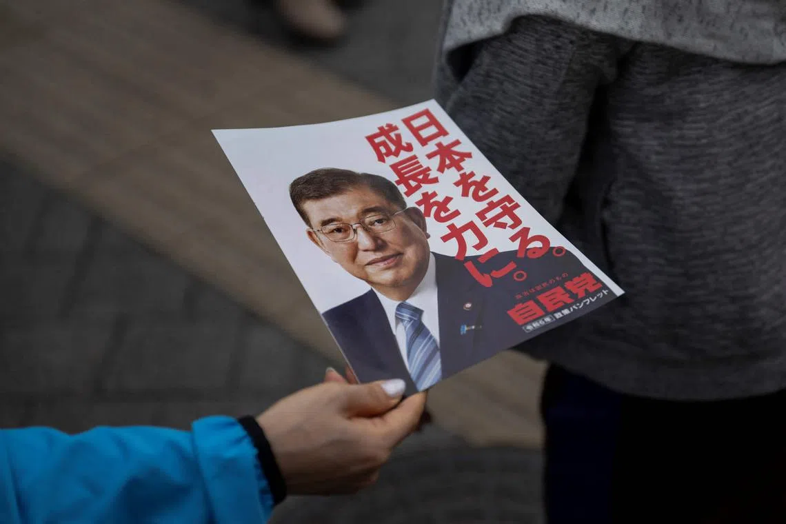 A flyer with a picture of Japan's Prime Minister Shigeru Ishiba is distributed at an election campaign speech in Tokyo on Oct 26, 2024.