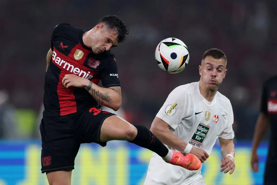 FILE PHOTO: Soccer Football - DFB Cup - Final - 1.FC Kaiserslautern v Bayer Leverkusen - Olympiastadion, Berlin, Germany - May 25, 2024 Bayer Leverkusen's Granit Xhaka in action with 1. FC Kaiserslautern's Boris Tomiak REUTERS/Thilo Schmuelgen/File Photo