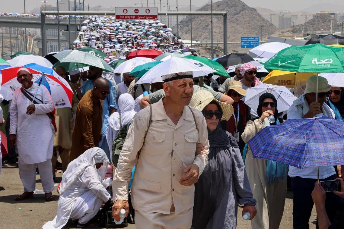 Muslim pilgrims walk with umbrellas on the third day of the Satan stoning ritual, amid extremely hot weather, during the annual haj pilgrimage, in Mina, Saudi Arabia, June 18, 2024. REUTERS/Saleh Salem


