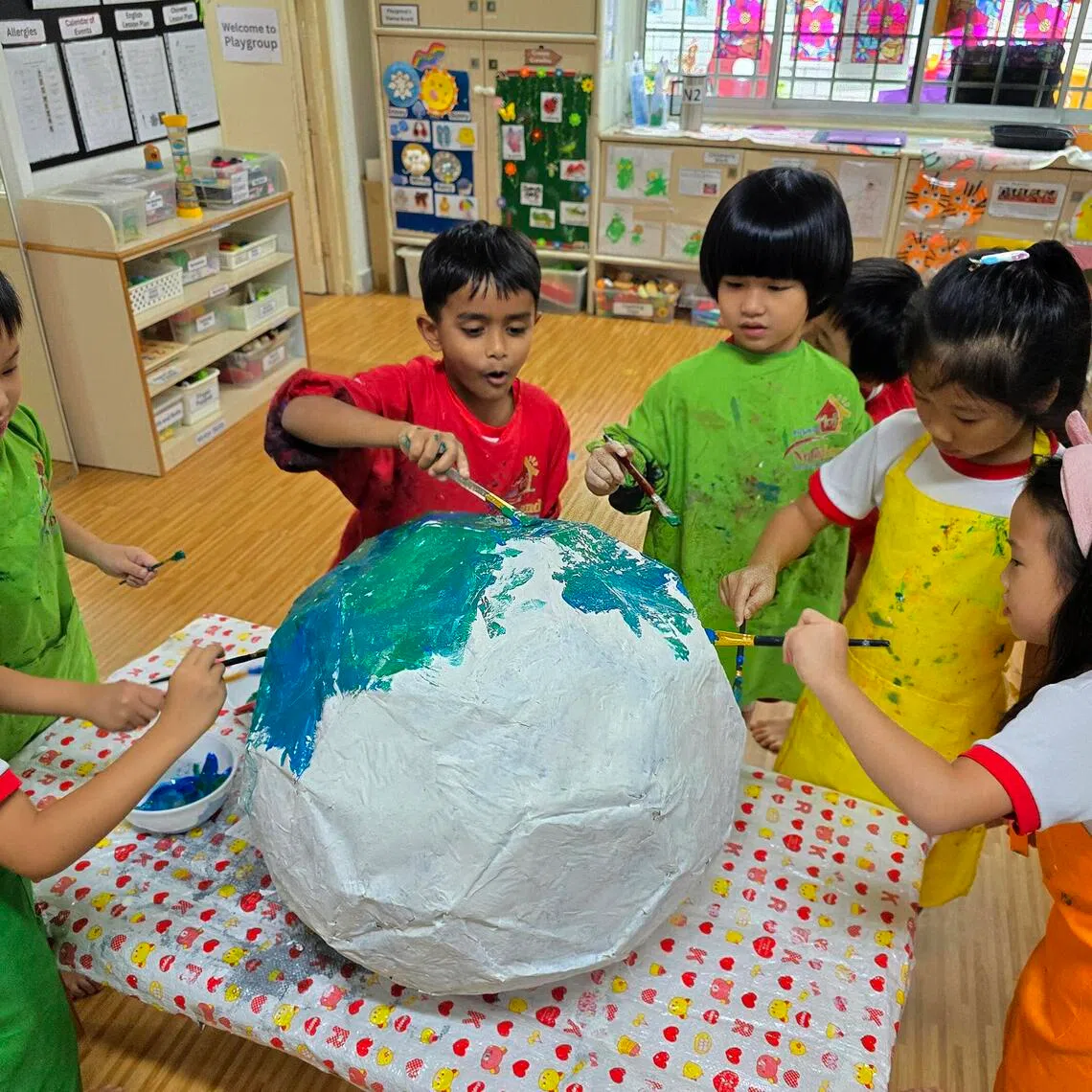Pre-schoolers have fun painting their creation together for the exhibition.
