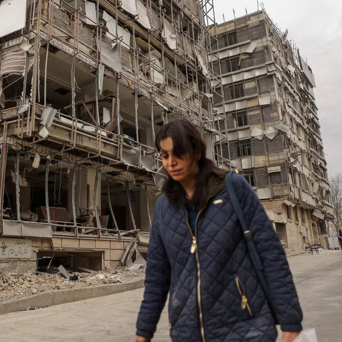 A woman walks on the street following an Israeli and U.S. strike on Gandhi Hotel Hospital, amid the U.S.-Israel conflict with Iran, in Tehran, Iran, March 2, 2026. Majid Asgaripour/WANA (West Asia News Agency) via REUTERS