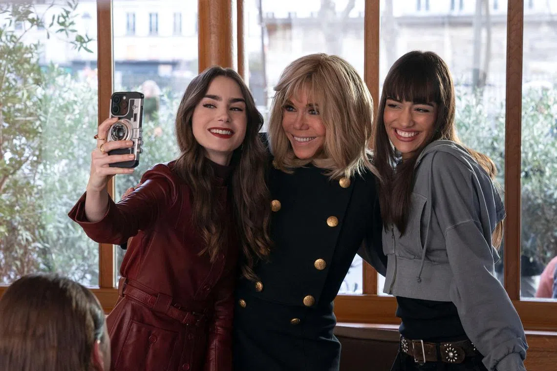 A handout photo from Netflix showing French first lady Brigitte Macron (centre), with actress Lily Collins (left), who plays Emily in Emily In Paris, and French actress Thalia Besson.