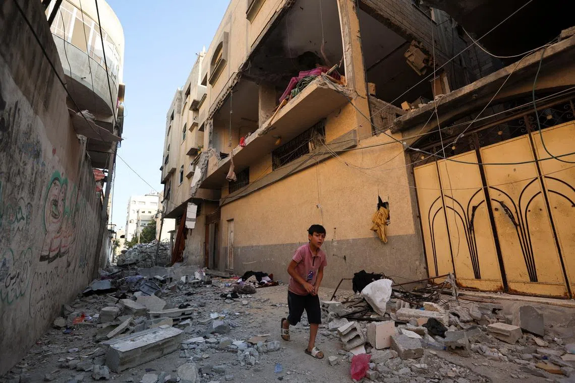 A Palestinian boy runs past the site of an Israeli strike on an apartment in Gaza City, June 20, 2026. REUTERS/Dawoud Abu Alkas