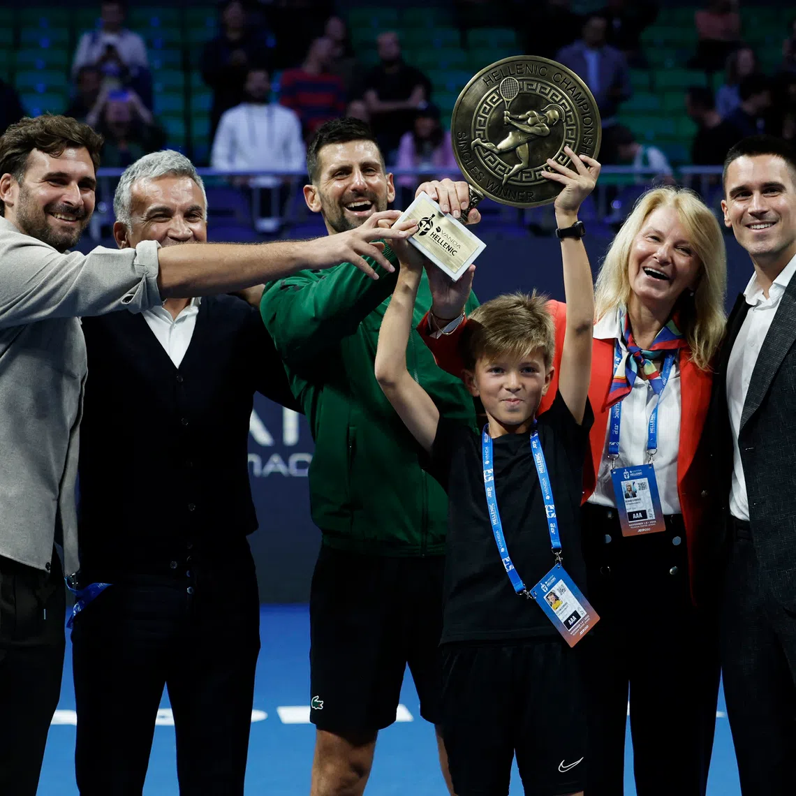 Tennis - ATP 250 - Hellenic Championship - Telekom Center Athens, Marousi, Greece - November 8, 2025 Serbia's Novak Djokovic celebrates with the trophy and his parents, Dijana Dokovic and Srdjan Djokovic, brothers Marko Djokovic and Djordje Djokovic, and his son Stefan after winning his final match against Italy's Lorenzo Musetti REUTERS/Louiza Vradi