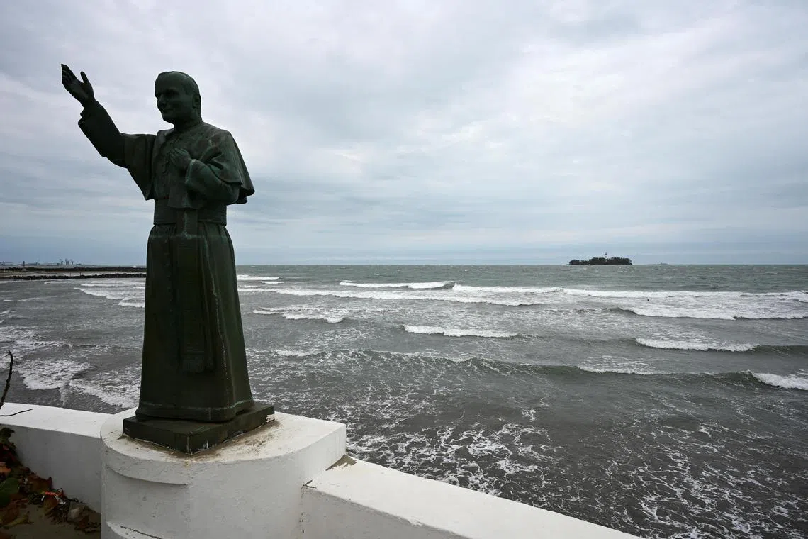 A statue of pope John Paul II is seen at a jetty as waves crash on the shore of the Gulf of Mexico in Boca del Rio, Veracruz state, Mexico. 
