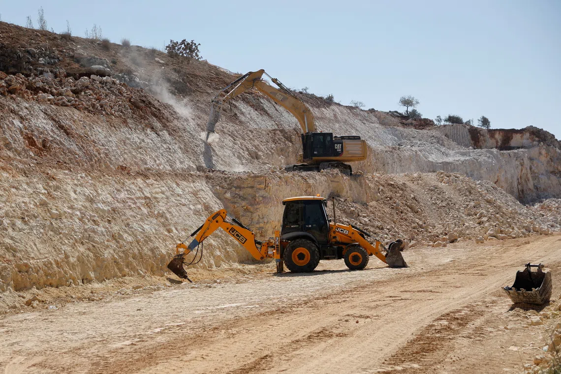 FILE PHOTO: Excavators expand an Israeli bypass road connecting Israeli settlers in the Israeli-occupied West Bank with Jerusalem, near Ramallah in the West Bank, September 29, 2025. REUTERS/Ammar Awad/ File Photo