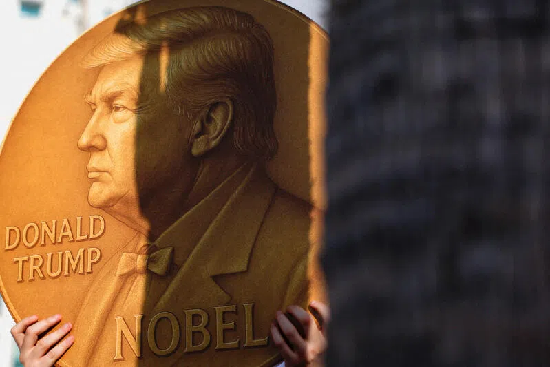 A protester holds a sign with an image depicting US President Donald Trump and the words "Nobel" written on it outside the US Consulate in Tel Aviv, Israel, on Sept 2, 2025.