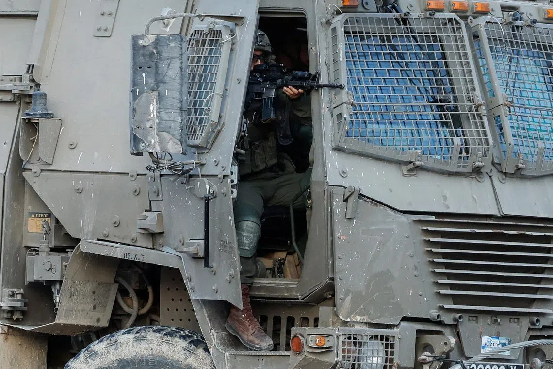 FILE PHOTO: An Israeli soldier holds a weapon in a military vehicle, during an Israeli raid in Tulkarm, in the Israeli-occupied West Bank, October 31, 2024. REUTERS/Raneen Sawafta/File Photo