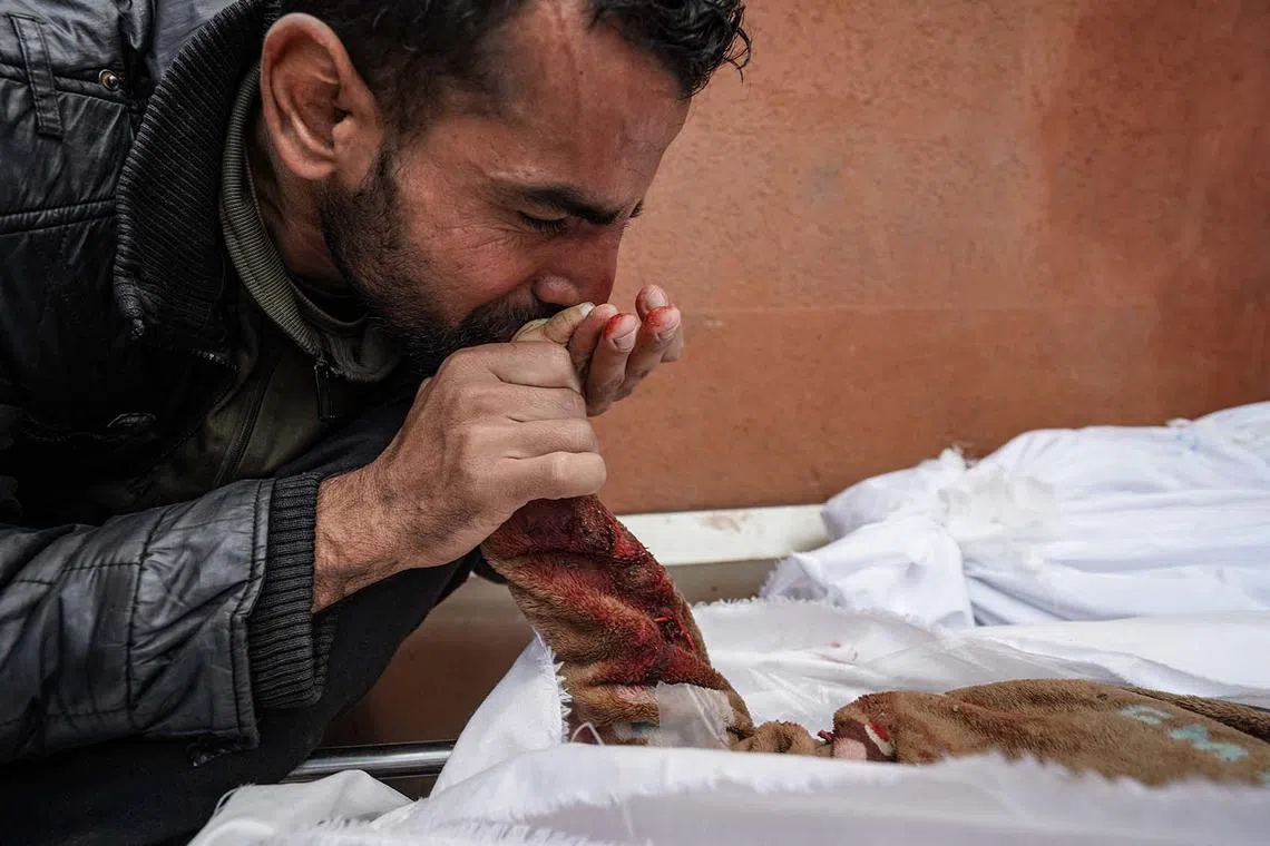 A Palestinian man mourns over the body of a relative killed in Israeli strike at the Nasser hospital in Khan Yunis on the southern Gaza Strip on Dec 28, 2023, amid continuing battles between Israel and the Palestinian militant group Hamas. 