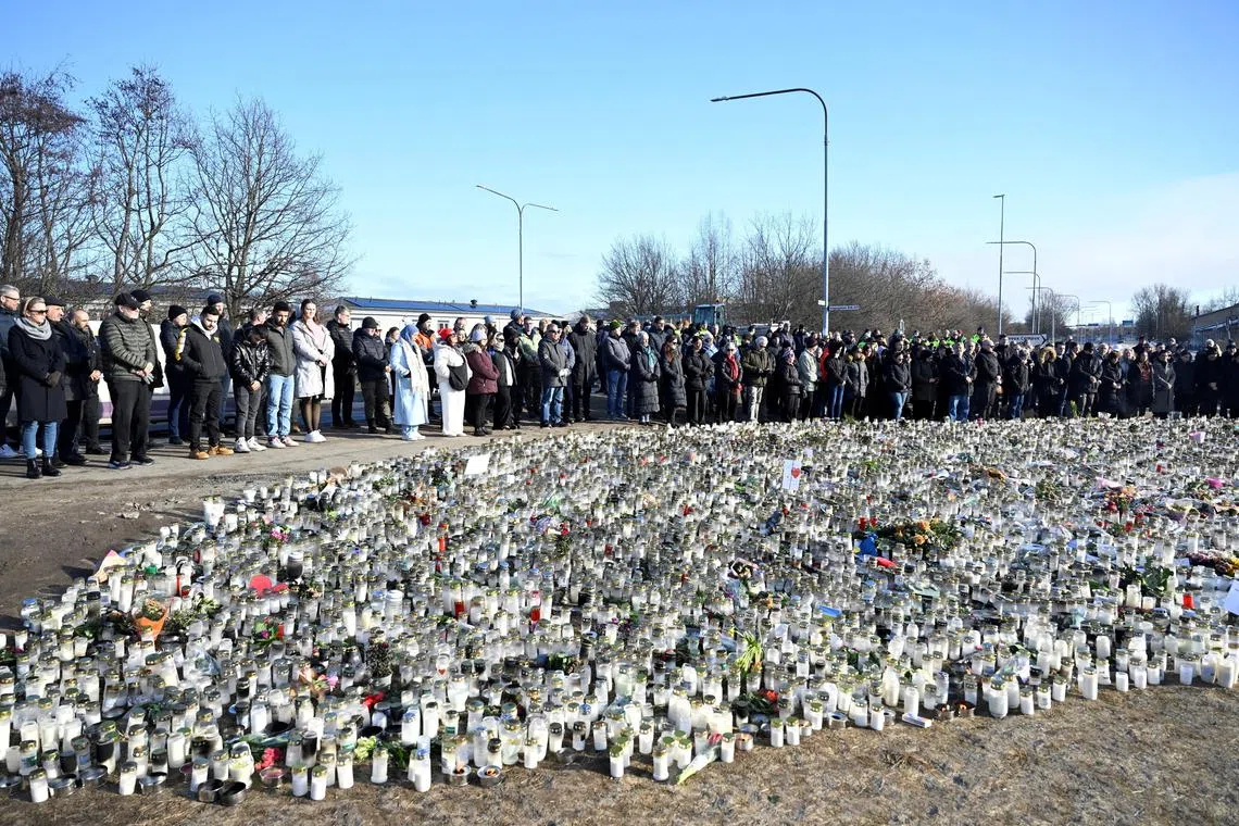 People gathering for a national minute of silence for the victims of the Risbergska School shooting, at a memorial site in Orebro, Sweden, on Feb 11.