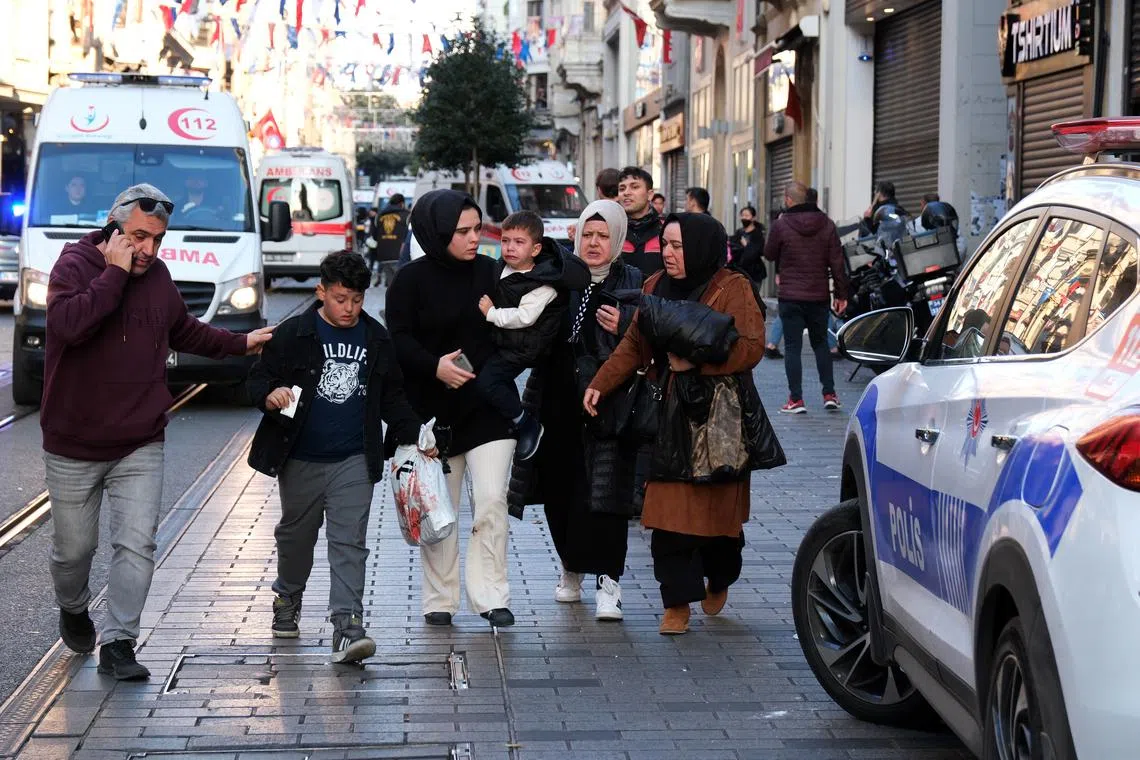 People run away as Turkish policemen try to secure the area after an explosion at Istiklal Street in Istanbul.