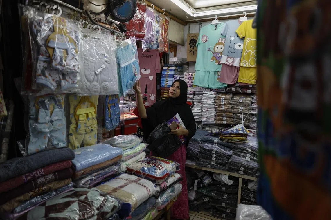 A customer checks clothes at a market in Jakarta, Indonesia, Dec 2, 2024.