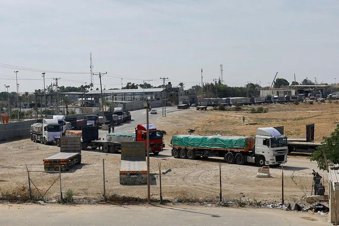 FILE PHOTO: Trucks carrying aid wait to exit, on the Palestinian side of the border with Egypt, as the conflict between Israel and Palestinian Islamist group Hamas continues, in Rafah in the southern Gaza Strip, October 21, 2023. REUTERS/Ibraheem Abu Mustafa/File Photo