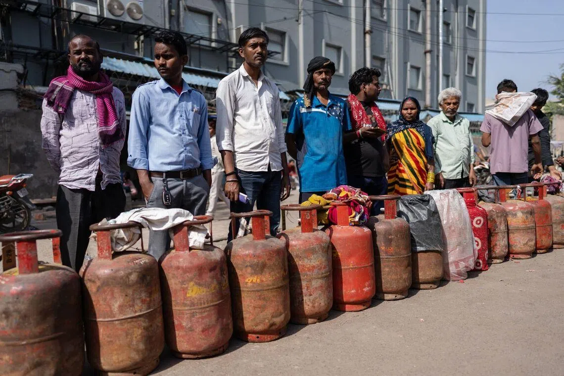 Buyers queue for liquefied petroleum gas (LPG) at a depot in Noida, Uttar Pradesh, on March 16.
