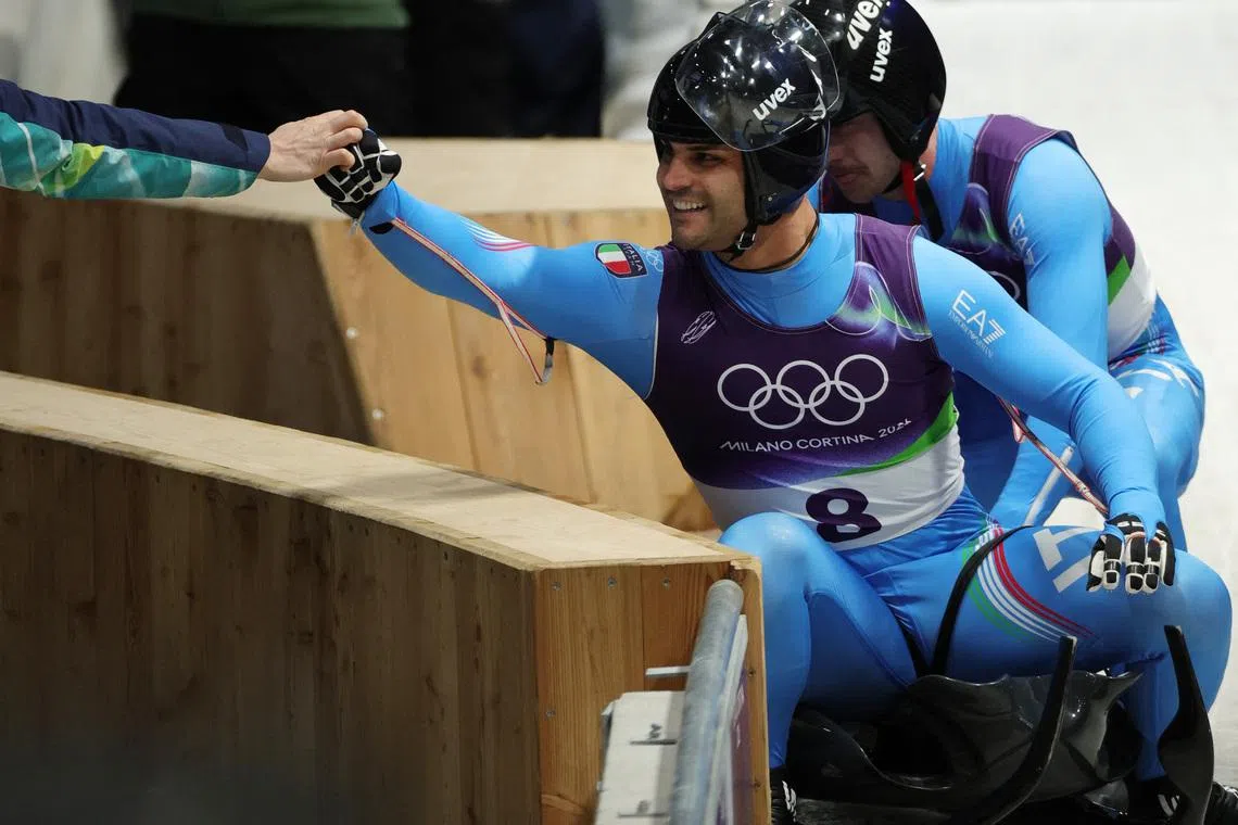Milano Cortina 2026 Olympics - Luge - Men's Doubles Run 2 - Cortina Sliding Centre, Cortina d'Ampezzo, Italy - February 11, 2026. Emanuel Rieder of Italy and Simon Kainzwaldner of Italy react after their run during the Men's Doubles Run 2 REUTERS/Athit Perawongmetha