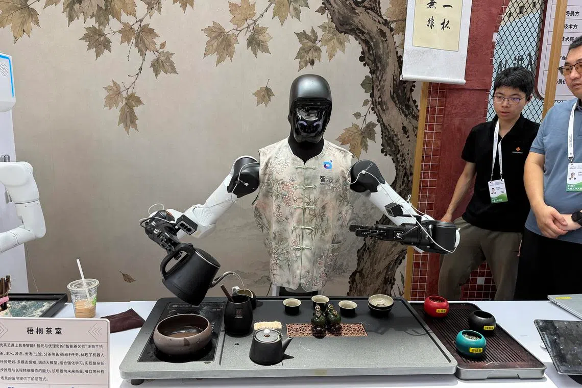 A humanoid robot pours tea for visitors at the World AI Conference in Shanghai.