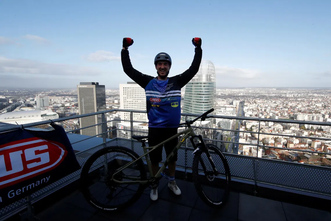 French professional mountain biker Aurelien Fontenoy reacts after climbing the 768 steps, 33 flors and 140 metres high Trinity Tower in the financial and business district of La Defense near Paris, France, January 17, 2021. REUTERS/Gonzalo Fuentes