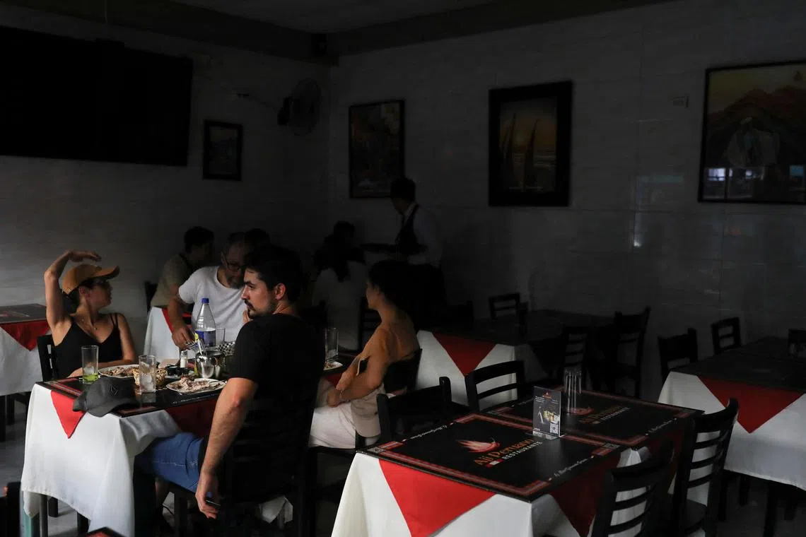 People sit inside a restaurant after a large power outage struck vast swaths of the country, in Santiago, Chile February 25, 2025. REUTERS/Pablo Sanhueza