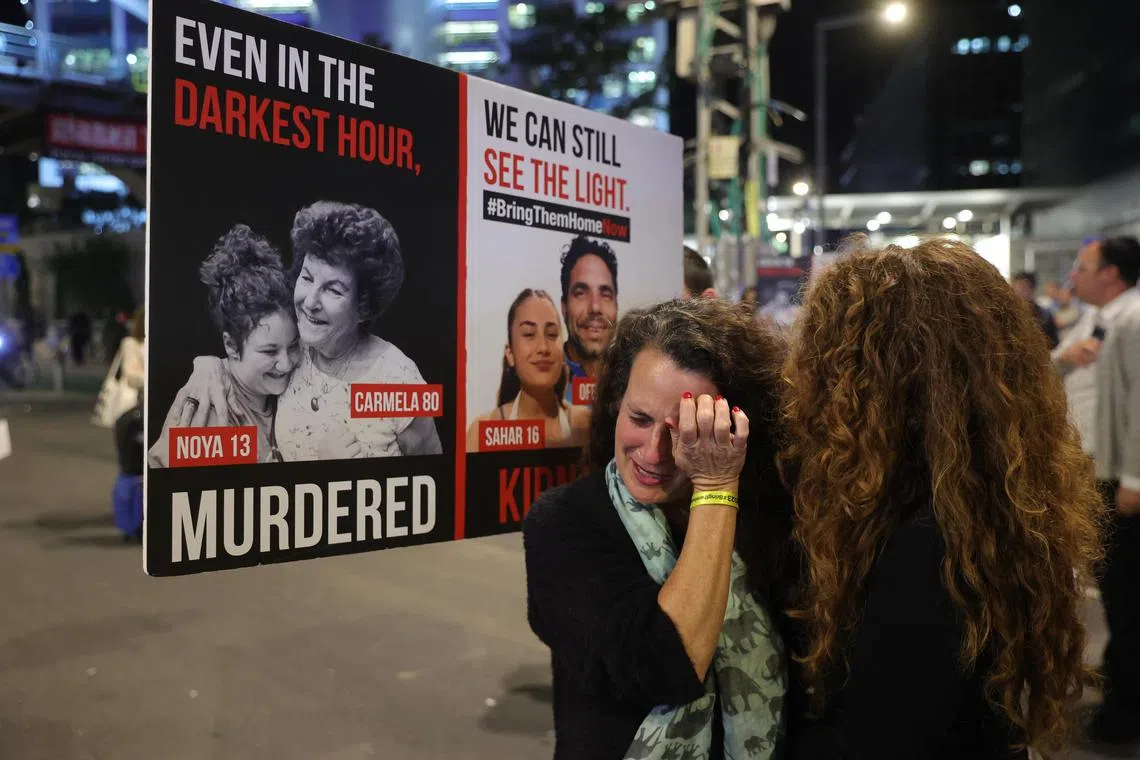 Ms Hadas Kalderon (centre), the mother of Israeli hostage Sahar and her husband Ofer Kalderon, cries during a protest calling on the government to sign an agreement with Hamas for a release of hostages.