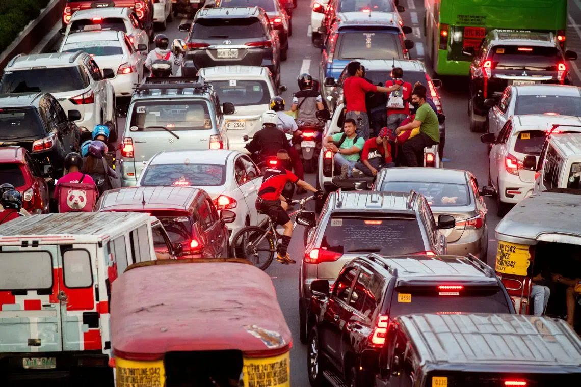 People ride at the back of a pick-up car amid heavy traffic as Christmas nears, in Quezon City, Metro Manila, Philippines, on Dec 16, 2022.
