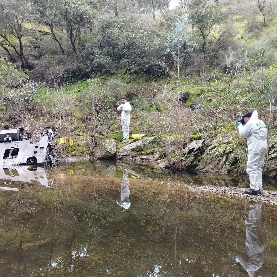 Investigators taking photographs of a train bogie in a stream, near the site where on Jan 18 a high-speed Iryo train derailed and hit another train in Adamuz, southern Spain. 