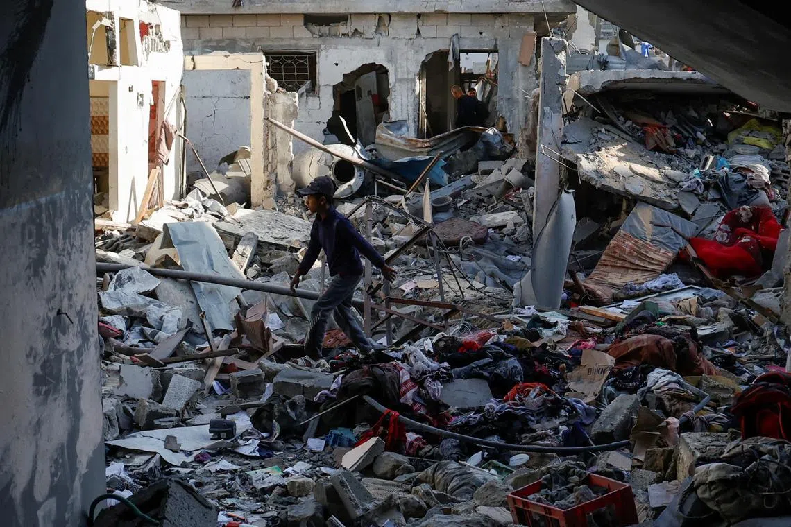 Palestinians inspect the site of an Israeli strike on a house, in Khan Younis in the southern Gaza Strip March 18, 2025. REUTERS/Hatem Khaled
