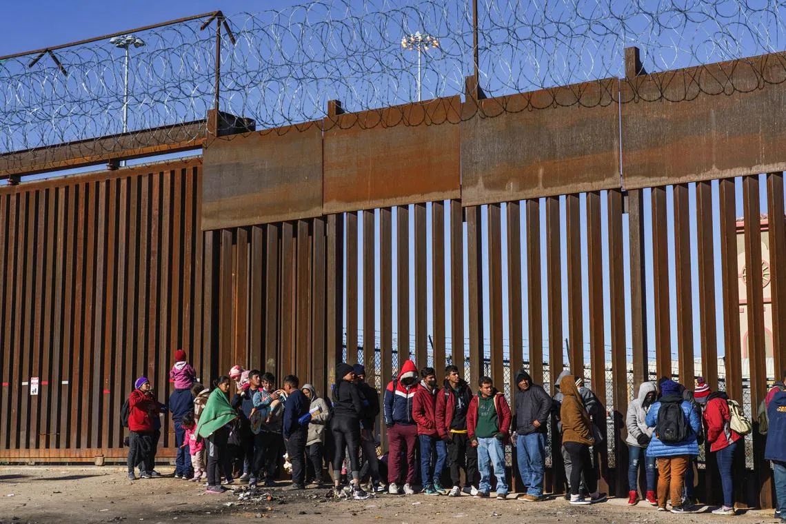 Migrants from Nicaragua, Ecuador and other nationalities are pictured at a door on the border wall waiting to be picked up by the United States Border Patrol in El Paso, Texas, U.S., January 4, 2023. REUTERS/Paul Ratje