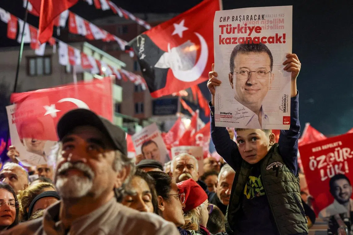 A supporter of Turkey's main opposition Republican People's Party (CHP) holds a poster with a picture of jailed Istanbul Mayor Ekrem Imamoglu with a slogan reading, during a rally in support of Imamoglu in Istanbul, Turkey, November 12, 2025.